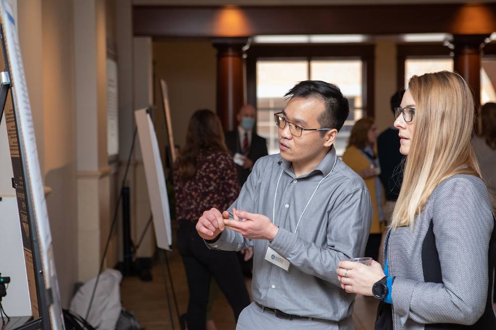 James Nguyen discussing his poster with Assistant Director of The Graduate School, Trista Bergerud.
